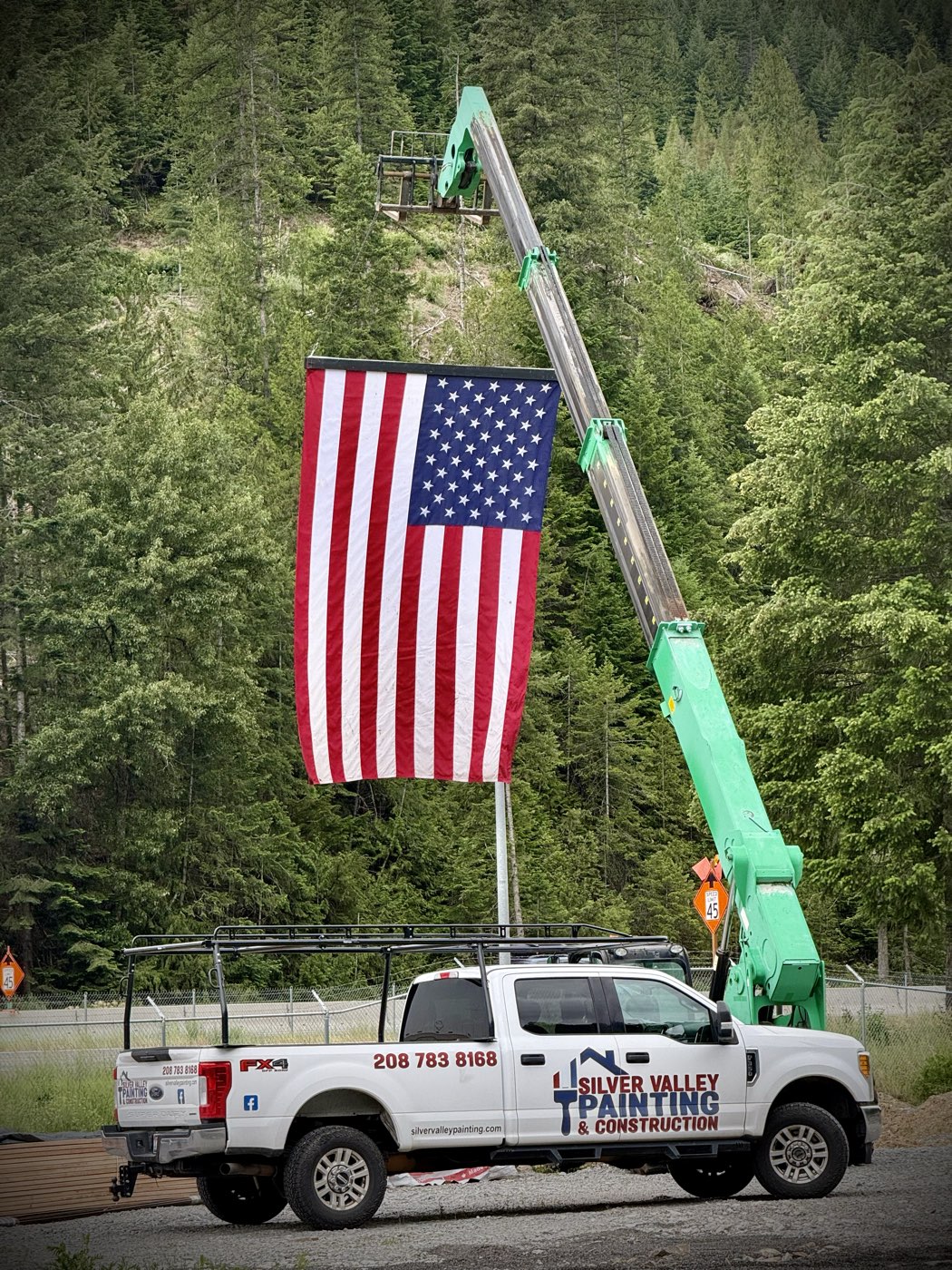 Silver Valley Painting & Construction truck raising an American flag in the North Idaho mountains