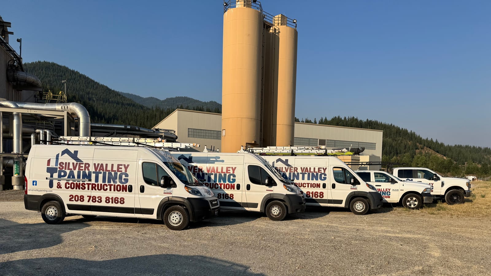 The Silver Valley Painting & Construction van and truck fleet staged at a commercial job site in the Silver Valley